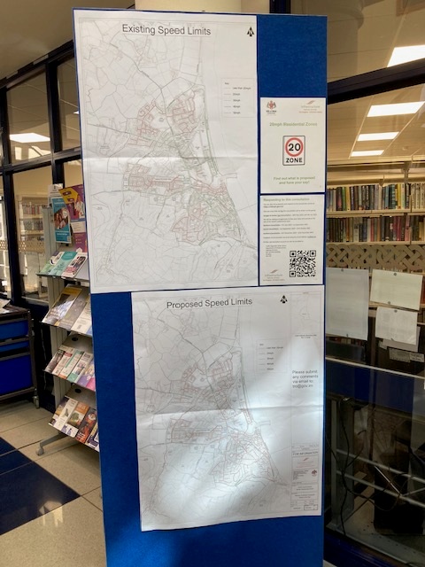 A display board featuring two maps: the top map shows existing speed limits in a residential area, while the bottom map illustrates proposed speed limits, highlighting a consultation for 20mph zones in Ramsey.